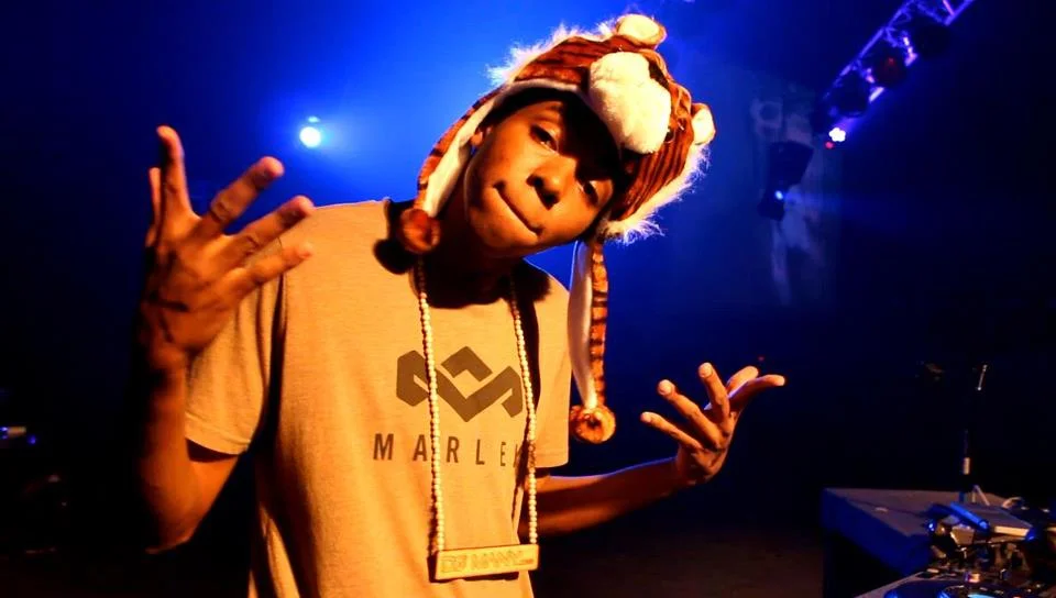 DJ Many performing under blue lights